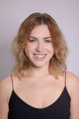 Fototapeta premium emotional portrait of a beautiful curly blonde-redhead in black undershirt. High quality photo
