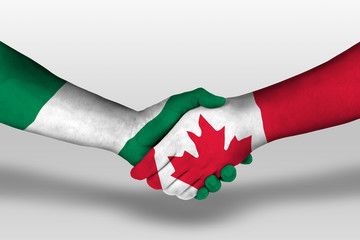 Handshake between canada and nigeria flags painted on hands, illustration with clipping path.