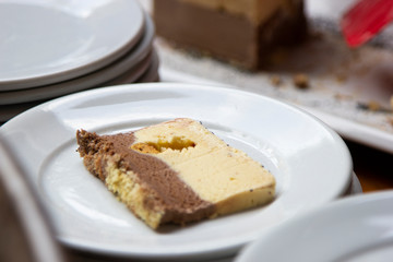 Refreshing cream ice cream with nuts and chocolate, served piece on plate.
