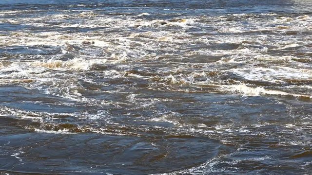 Panning across rapids in slow motion. The water slowly swirls and churns. Slowed down from 120 FPS. Reversing Falls at low tide in Saint John, New Brunswick, Canada.