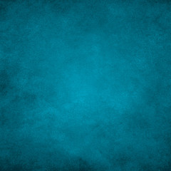 Fototapeta na wymiar Dark turquoise grunge paper texture background with darkened edges and glowing center.