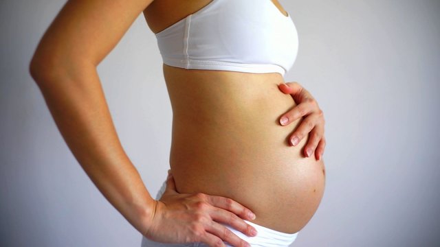 A profile of the body of a young pregant woman