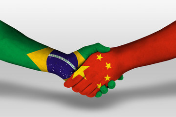 Handshake between china and brazil flags painted on hands, illustration with clipping path.