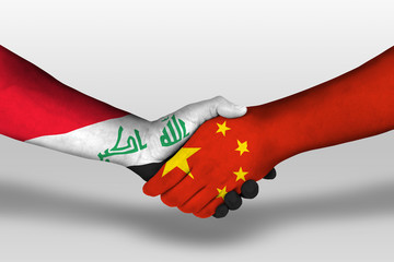 Handshake between china and iraq flags painted on hands, illustration with clipping path.