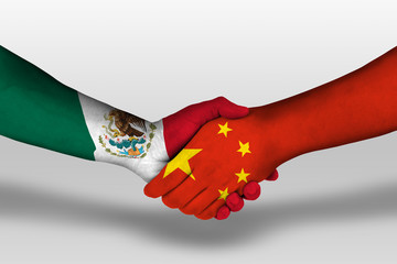 Handshake between china and mexico flags painted on hands, illustration with clipping path.