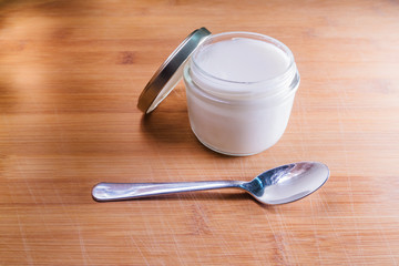 Fototapeta na wymiar homemade yogurt and spoon on a wooden background