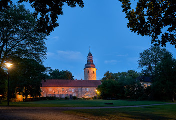 illuminated medieval former monastery and tower of the church St. Viti in Zeven (Germany) seen...