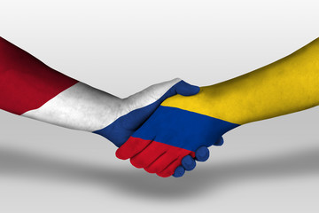 Handshake between columbia and netherlands flags painted on hands, illustration with clipping path.