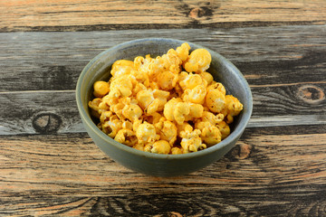 Hot spicy barbecue popcorn snack in ceramic bowl on table