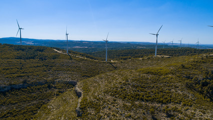 Aerial view of Wind Generating stations at big first mountains on a background of blue sky. Spain