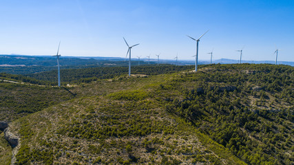Aerial view of Wind Generating stations at big first mountains on a background of blue sky. Spain