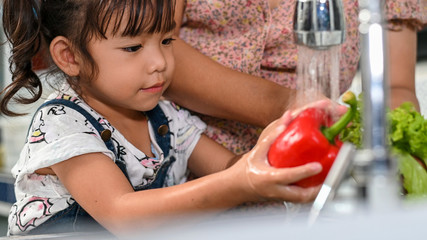 Asian mother get her daughter ready to school