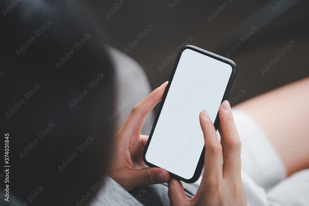 Poster woman's hand holding black mobile phone with blank desktop screen. empty screen for mockup image or 