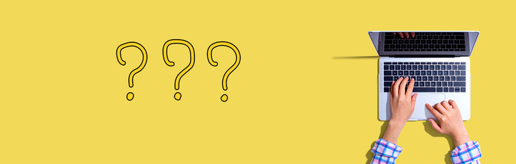 Question marks with woman using a laptop computer