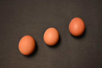 Three chicken eggs isolated on black background