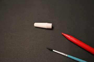 The red marker and brush isolated on black background