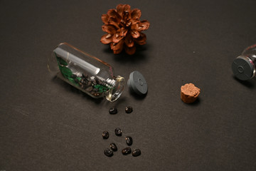 Dried seeds of telang flower ( clitoria ternatea L. ) were put inside and outside bottle isolated on black background 