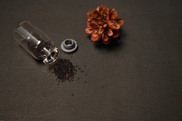 Dried seeds of spinach were put inside and outside bottle isolated on black background 