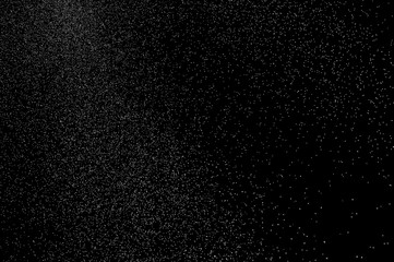 Abstract splashes of water on black background. Freeze motion of white particles. Rain, snow...