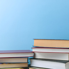 Stacks of books several on a blue background close-up. Back to school, education, learning,