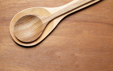 Wooden spoon on wooden background.