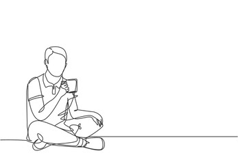 One continuous line drawing of young happy attractive worker sitting on the floor while holding a cup of coffee and thinking some ideas. Drinking tea concept graphic design vector illustration