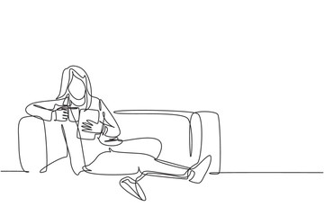 One continuous line drawing of young businesswoman lying down on the sofa while reading book and holding a cup of coffee drink. Drinking tea concept single line draw vector design graphic illustration