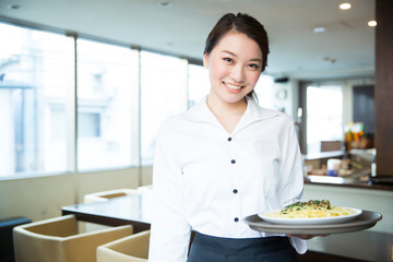 料理を運ぶ女性店員