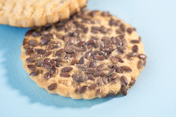 Heap of cookies with flax seeds on blue background