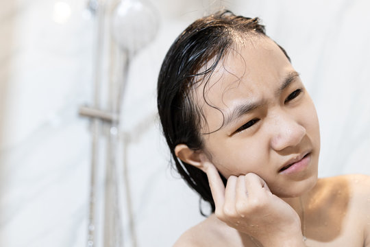 Stressed Asian Child Girl Had Tinnitus Water In Her Ear Canal While Washing Hair, Sad People Is Covering Her Ear With Her Finger, Congestion Of The Ear With Water While Taking A Shower In The Bathroom