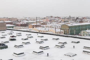 Fototapeta na wymiar Rooftop of industrial building covered with snow in Saint Petersburg