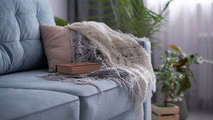 cozy living room with a turquoise sofa. book is lying on a sofa, the concept of a literary circle