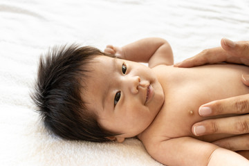 Obraz na płótnie Canvas 赤ちゃんの体にベビーマッサージをするイメージ