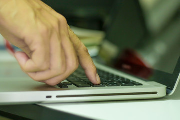 Single finger press on laptop keyboard, close up ..