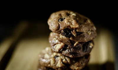 Homemade sweet chocolate cookies on wooden table with black background