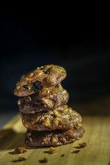 Homemade sweet chocolate cookies on wooden table with black background