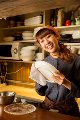 お皿を拭く女性店員