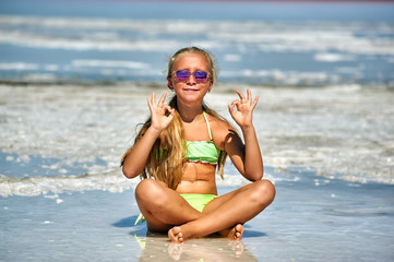 A little girl is engaged in yoga and meditation at a Spa resort . Concept of children's health recreation
