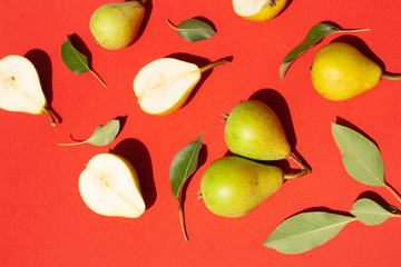 Green ripe pears on a red background. Flat Lay style. Harvest concept
