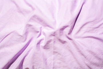 The folds of rumpled lavender bedding. Texture background. Flat lay style