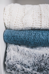 Fototapeta na wymiar winter lifestyle concept, soft and fluffy blankets and throws stack