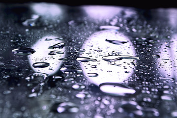 Closeup of waterdrops on a surface under the lights - perfect for wallpapers and backgrounds