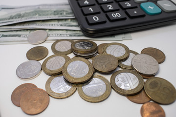 a pile of pennies lying on a blurry background of dollars with a calculator. Growth of the currency against the ruble