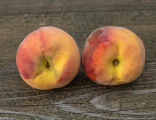 Two juicy peaches on a wooden background