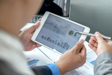 Two business leaders talk about charts, financial graphs showing results are analyzing and calculating planning strategies, business success building processes