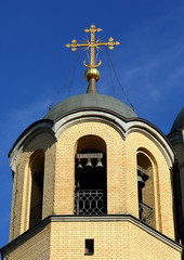 Fototapeta na wymiar Bell tower of the yellow brick Orthodox Church, Rozhdestvenskaya Church, ulitsa Kollontai 17, Saint Petersburg, Russia, August 2020