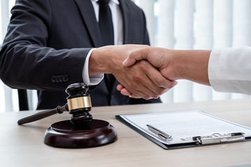 shake hand Professional male lawyers work at a law office There are scales, Scales of justice, judges gavel, and litigation documents. Concepts of law and justice