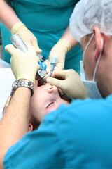 The anesthesiologist inserts a breathing tube into the child's trachea.Preparation before surgery. Life-saving or health-care concept. Copy of the space.Vertical photo. - obrazy, fototapety, plakaty