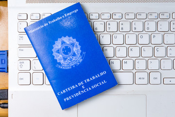 Carteira de trabalho brasileira sobre o teclado do computador. Trabalhando em home office.