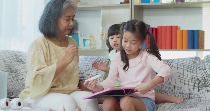 Grandma happily looking her granddaughter drawing on white board